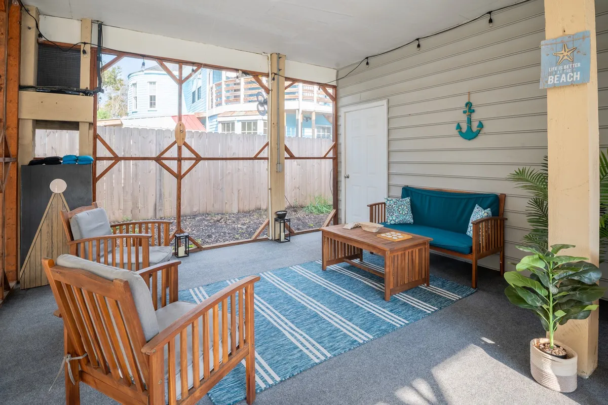 A cozy seating area with wooden chairs, a coffee table, and anchored wall decor, bathed in natural light. The space gives the feeling of a relaxed retreat, perfect for sharing stories after a day of adventure.
